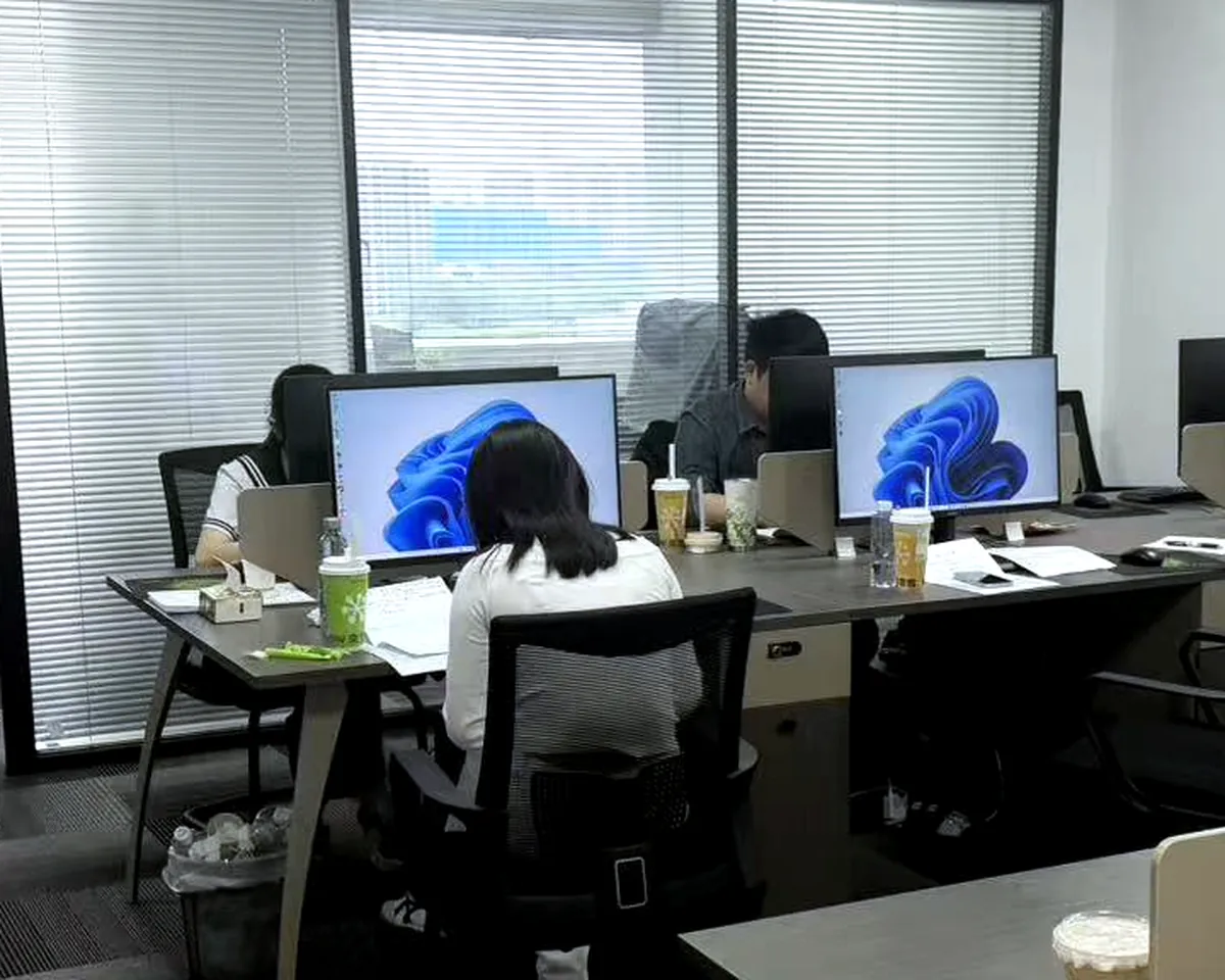 Team members working at their systems across a shared office floor.
